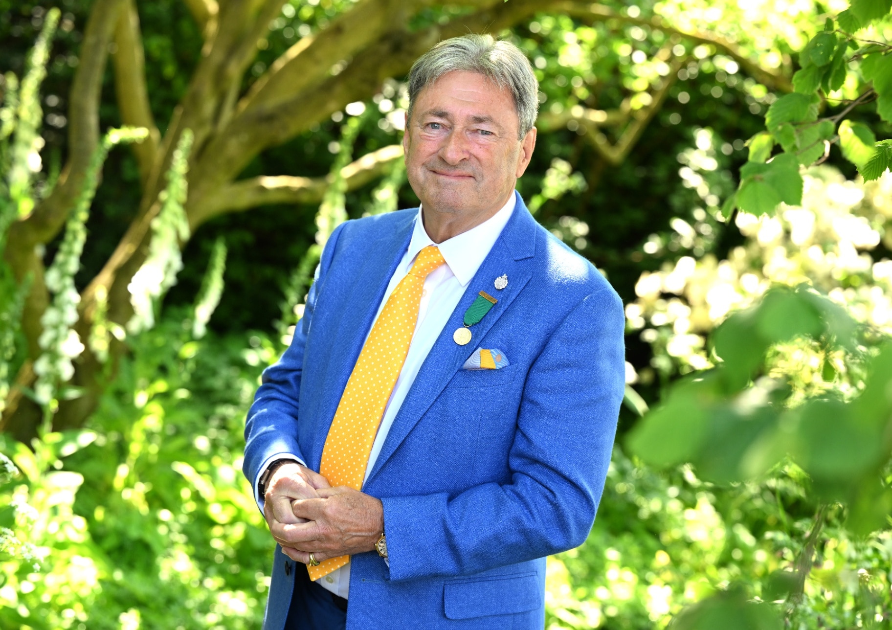 Alan Titchmarsh in a suit with garden background 