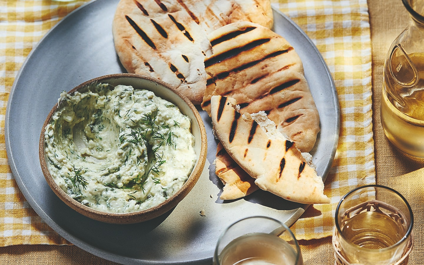 Courgette and feta dip in a bowl with flatbreads.