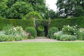 Scenic View of a Beautiful English Style Landscape Garden with a Green Mowed Lawn and Colourful Flower Bed in Bloom