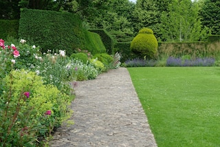 Scenic view of a stone paved path in a beautiful English style landscape garden 